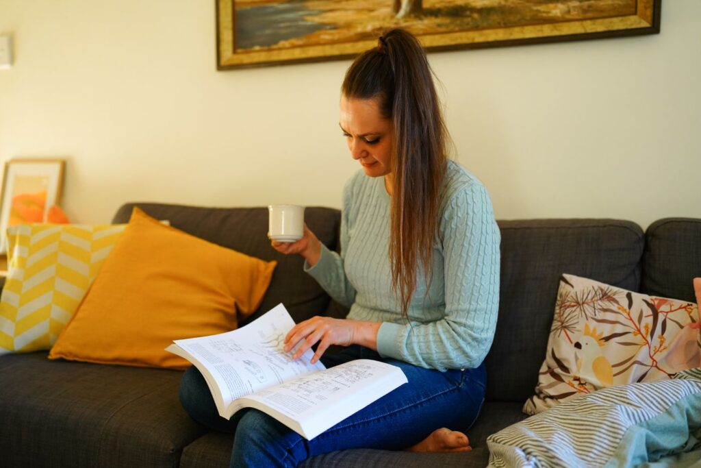Koren Helbig on the couch, reading a book, during a quarterly rest week.
